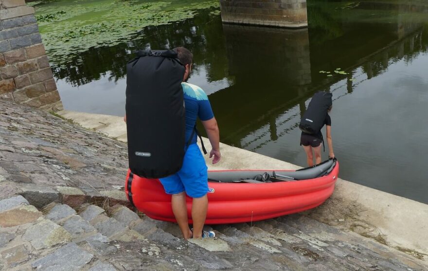 Přenášení jezu s vodotěsnými vaky Ortlieb A-Tremer a X-Plorer.